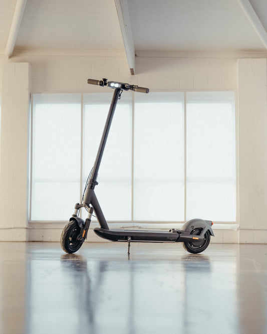 Sleek electric scooter displayed indoors, showcasing its compact design and stylish build.