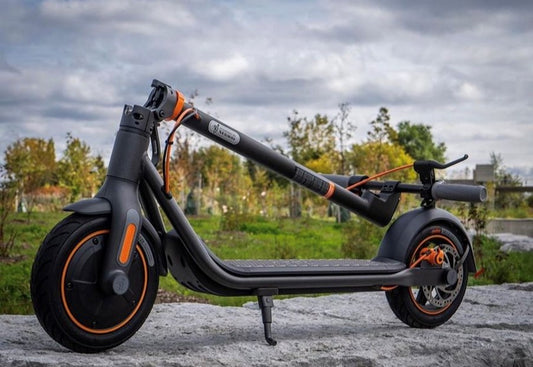 Stylish black electric scooter with orange accents parked outdoors